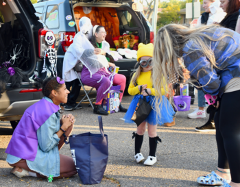 At a trunk-or-treat event, a child dressed as a Minion from 