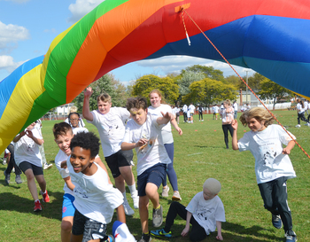 Students running through rainbow inflatables at Fun Run