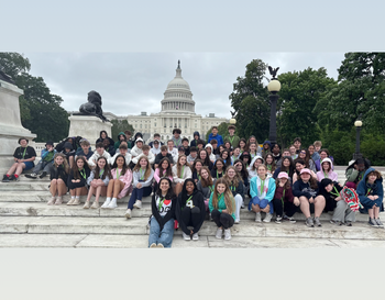 Group of students posing on the steps in front of the United States Capitol Building.