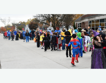 Students lined up in Halloween costumes in front of school building