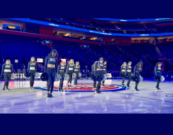 Members of the BHS Dance Team performing a routine on the basketball court at Little Caesars Arena.